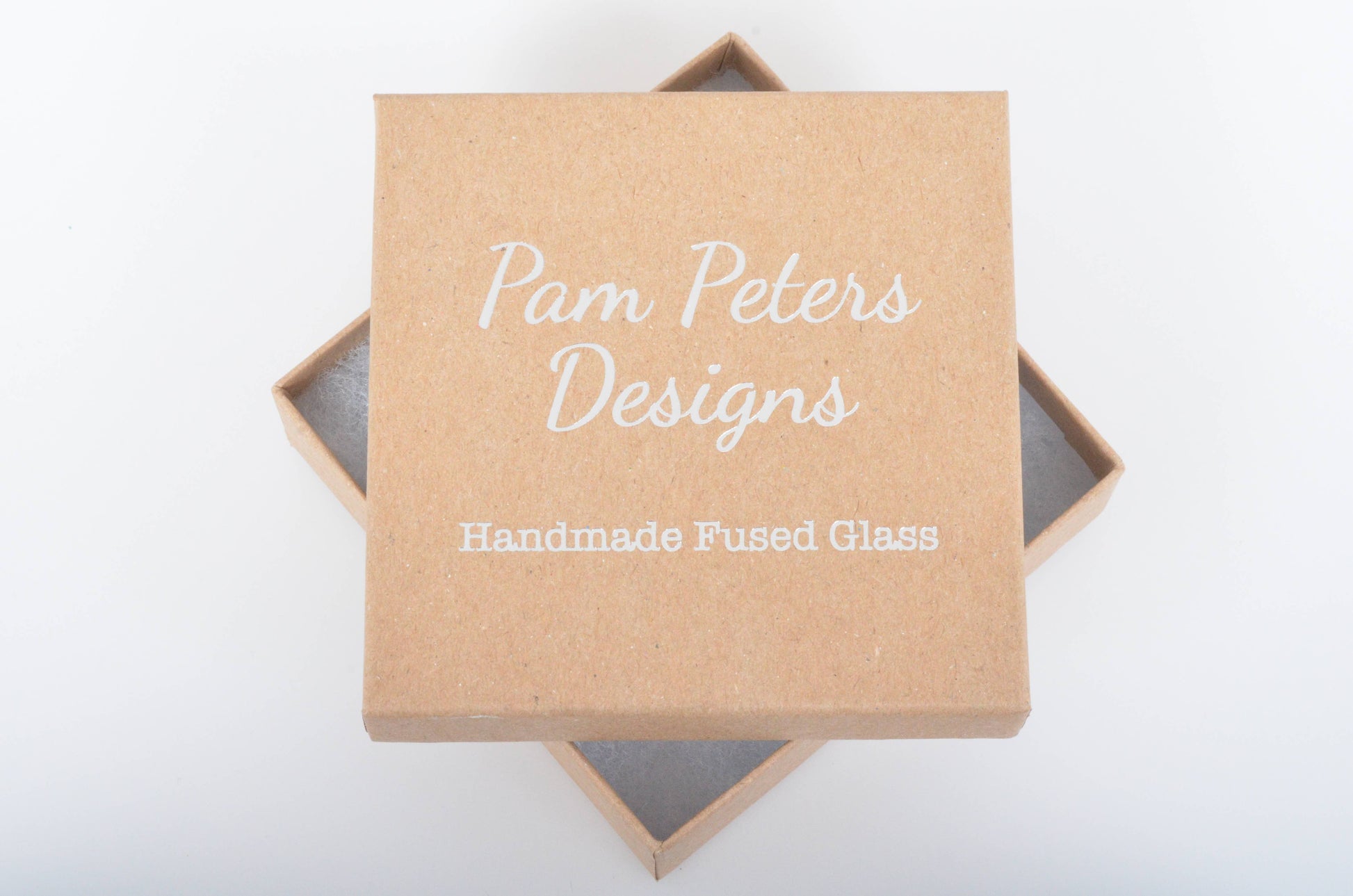 Kraft paper box with 'Pam Peters Designs' branding on a white background