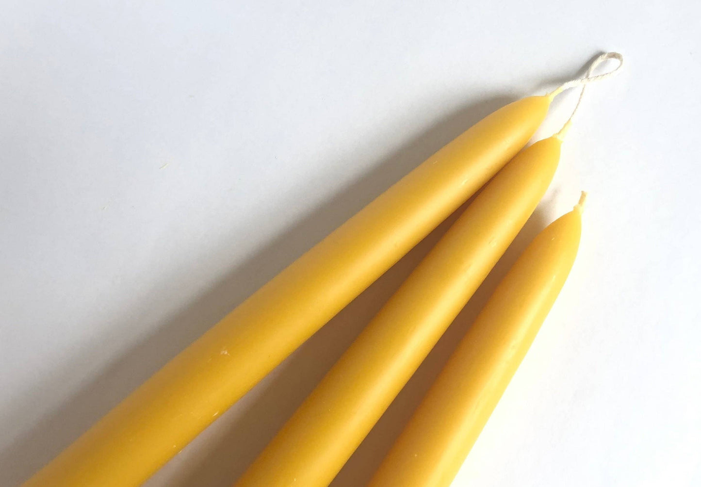 Two yellow candles on a white background