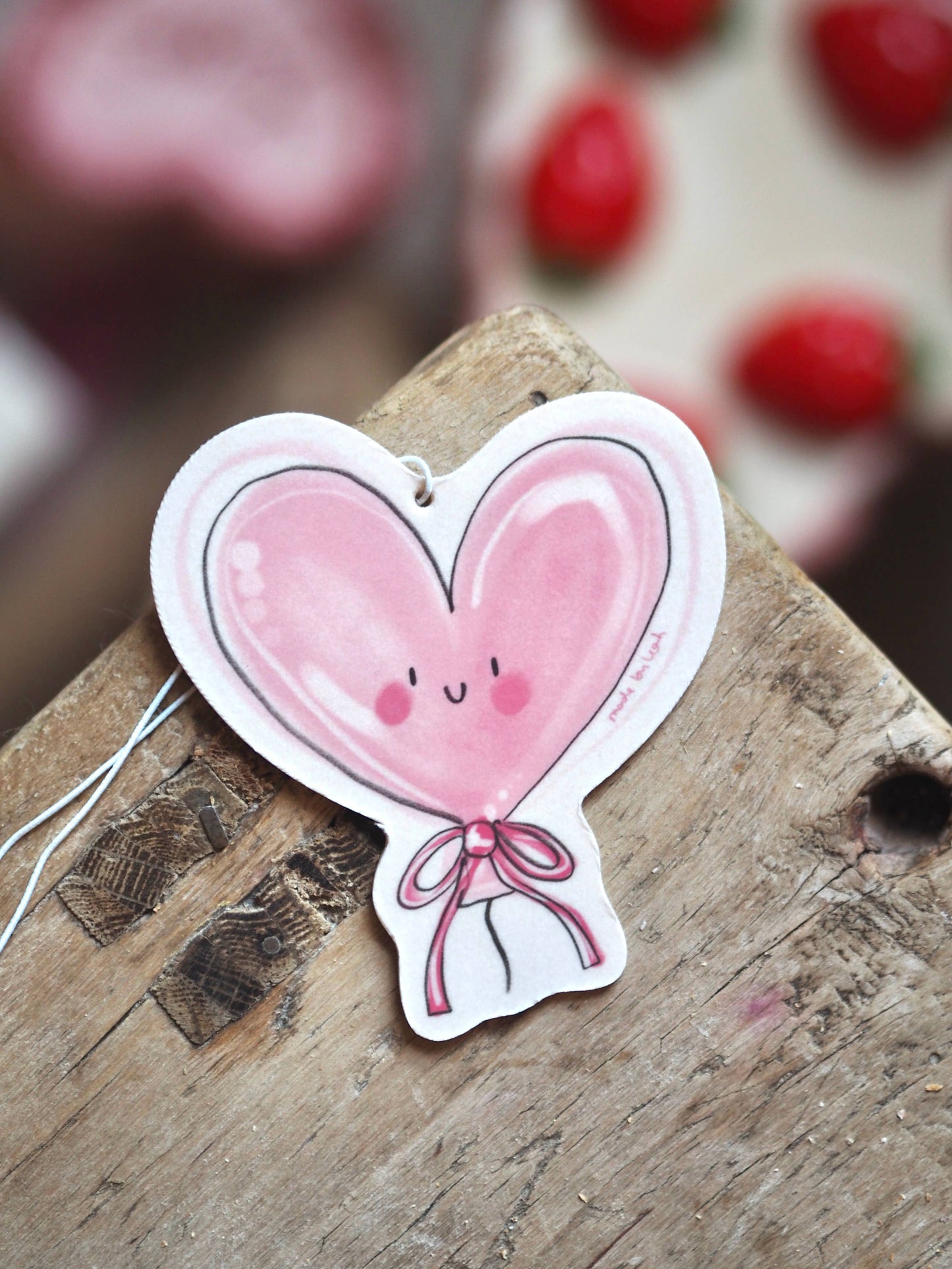 Heart-shaped balloon with a face on a wooden surface