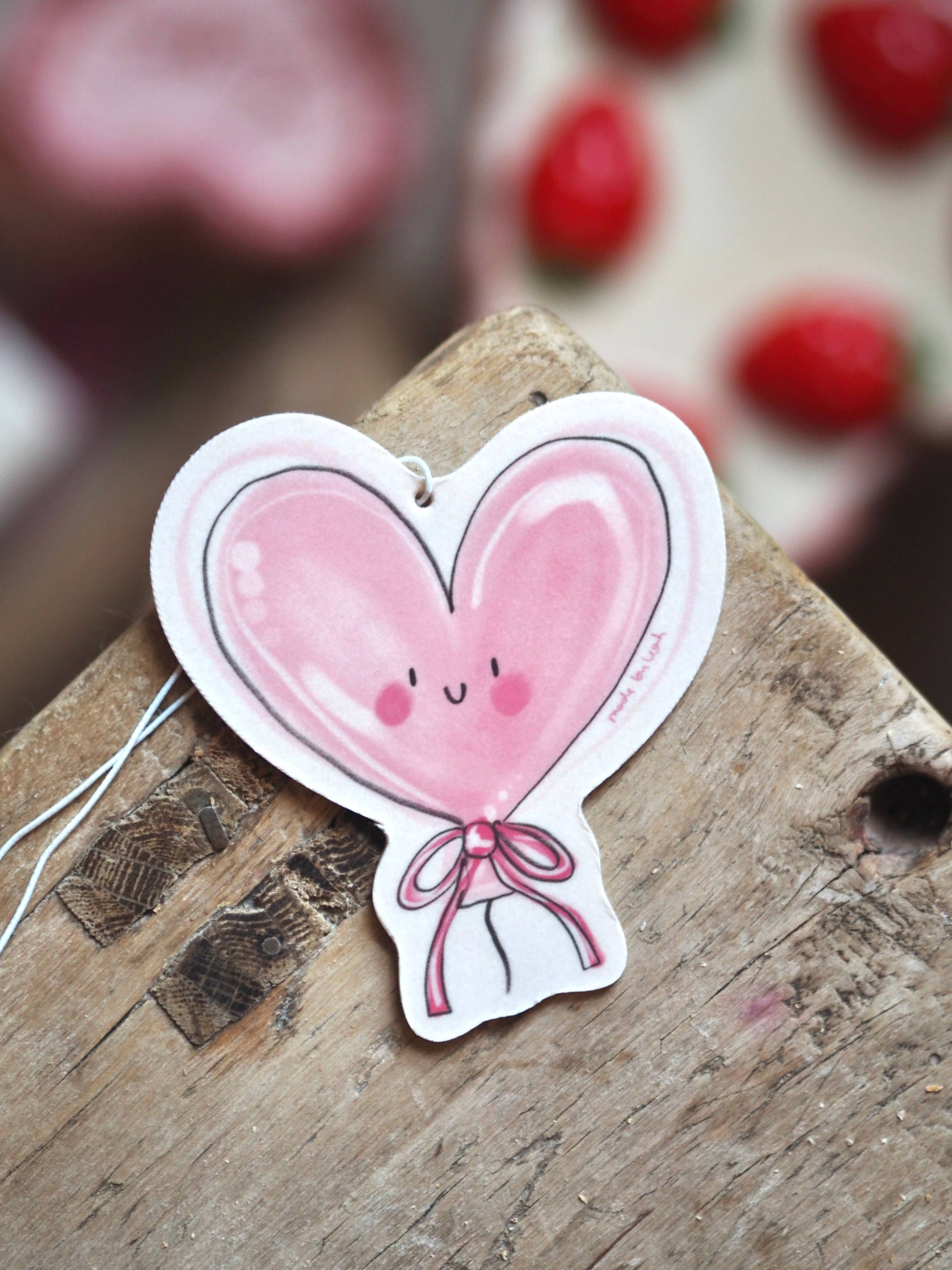 Heart-shaped balloon with a face on a wooden surface