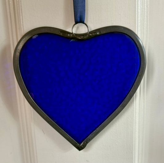 A medium sized Glass heart with a lead edging and a copper wire hook to hang in a window or outside in a tree