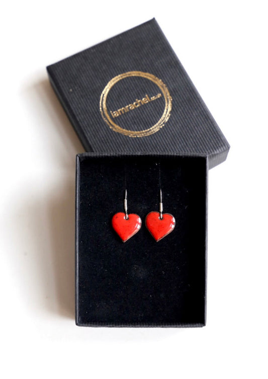 Small red heart shaped enamel earrings with sterling silver hoops.