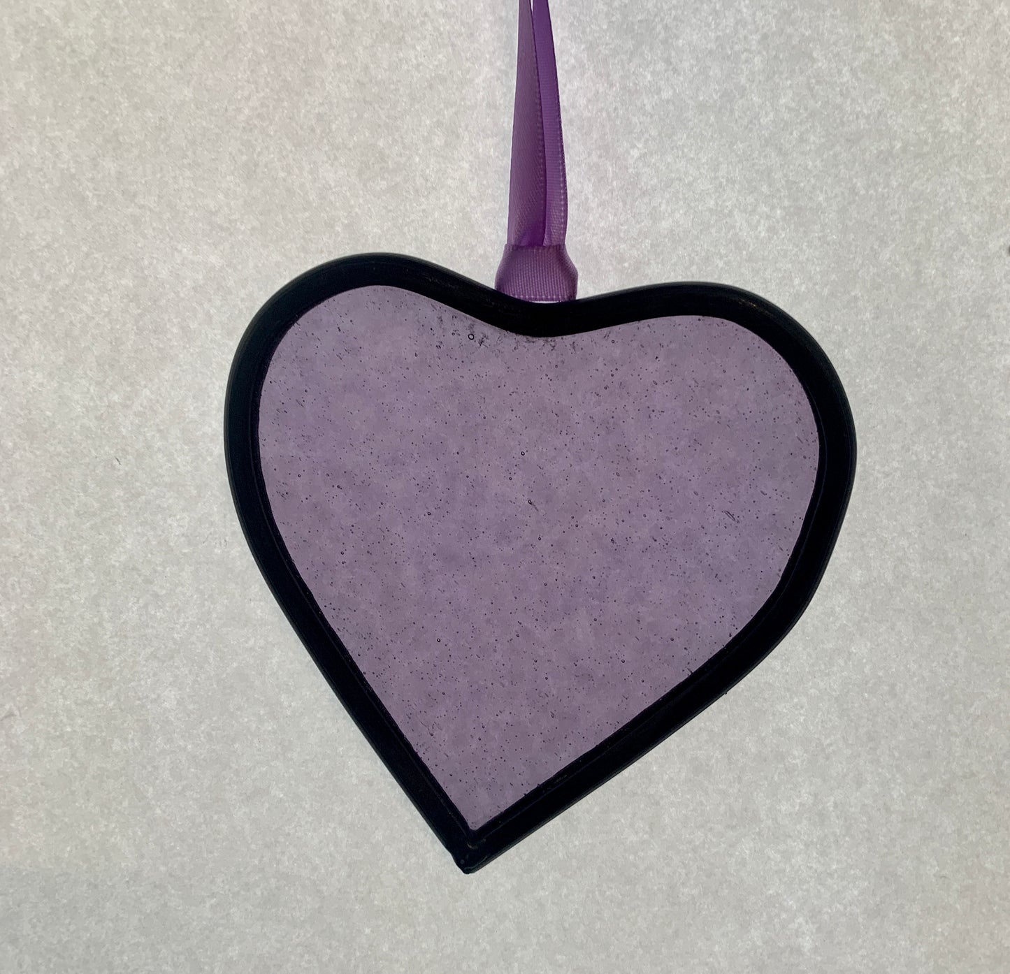 A medium sized Glass heart with a lead edging and a copper wire hook to hang in a window or outside in a tree