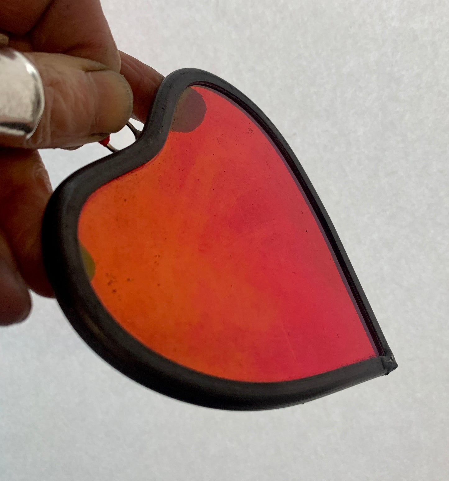 A medium sized Glass heart with a lead edging and a copper wire hook to hang in a window or outside in a tree