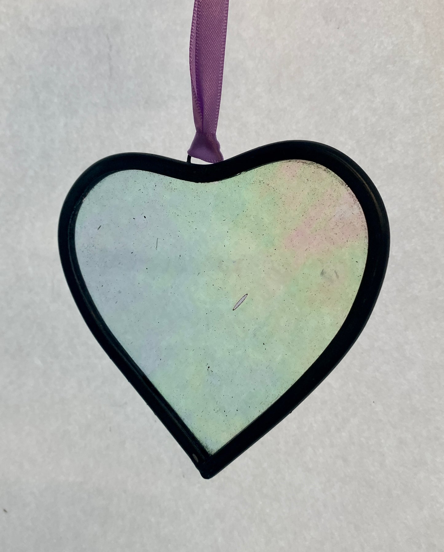 A medium sized Glass heart with a lead edging and a copper wire hook to hang in a window or outside in a tree