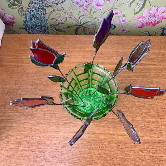 A stained glass rose bud on a copperwire stem.