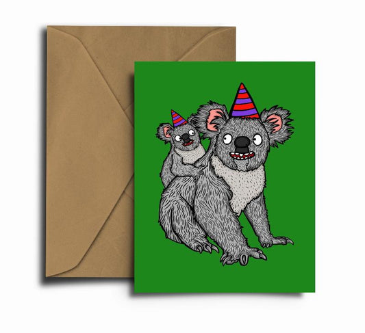 Card with illustration of koalas in party hats. Green background.