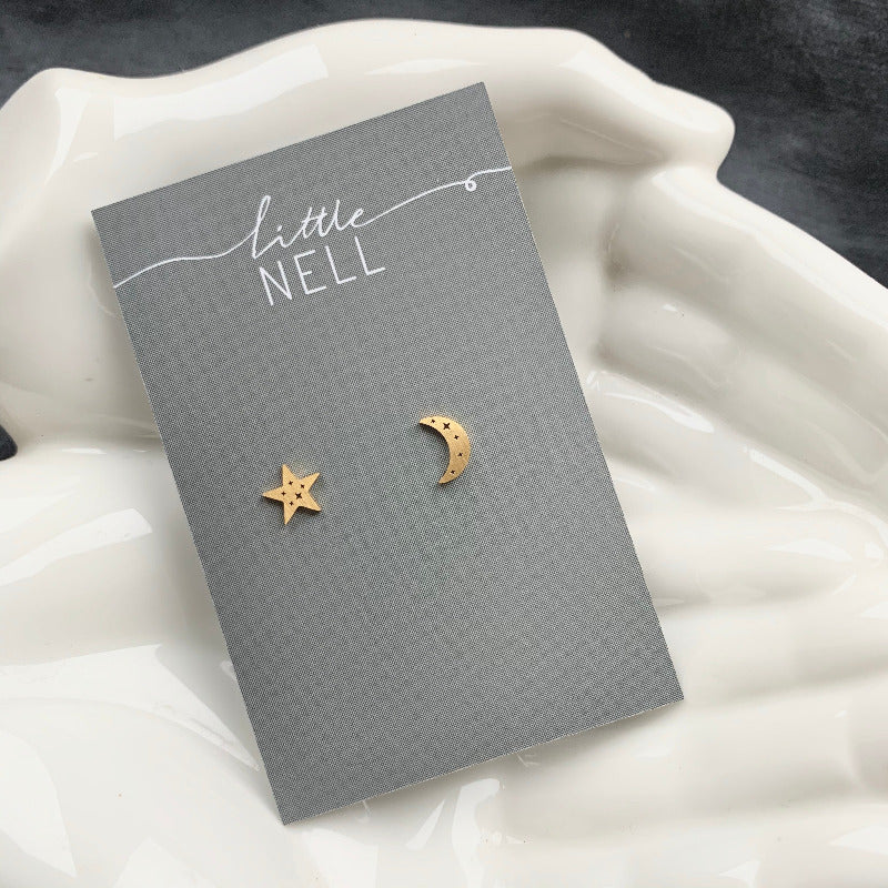 A pair of gold moon and star studs etched with tiny constellations.