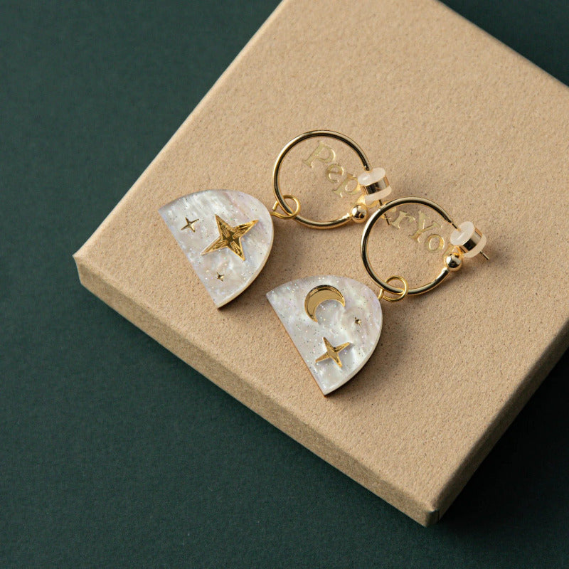 Gold small hoop earrings with white semi circle with gold crescent moon and stars