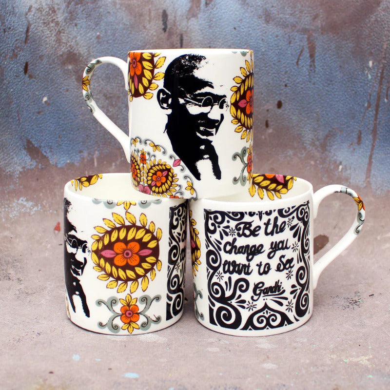 A bone china mug with image of colourful flowers and Gandhi and his phrase Be The Change You Want To See