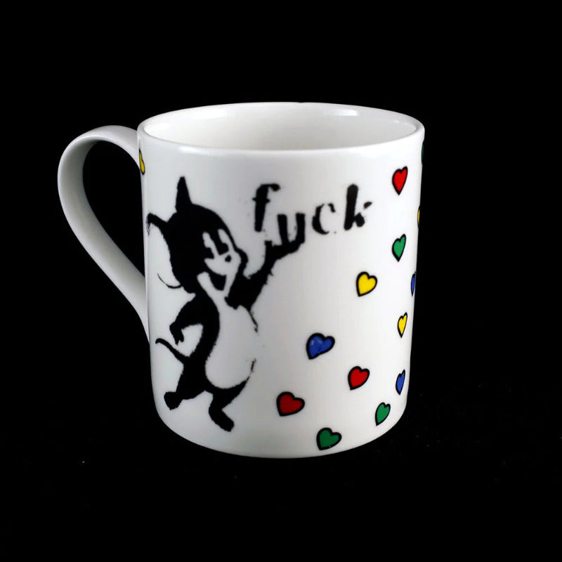Bone china mug illustrated with coloured hearts on white with the text Carpe Fucking Diem. This side shows a smiling cat holding the word Fuck