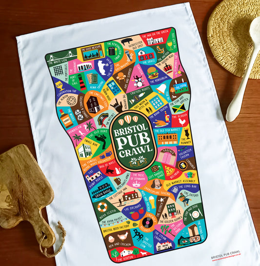 A colourful tea towel on the shape of a pint glass featuring 75 pubs in Bristol.