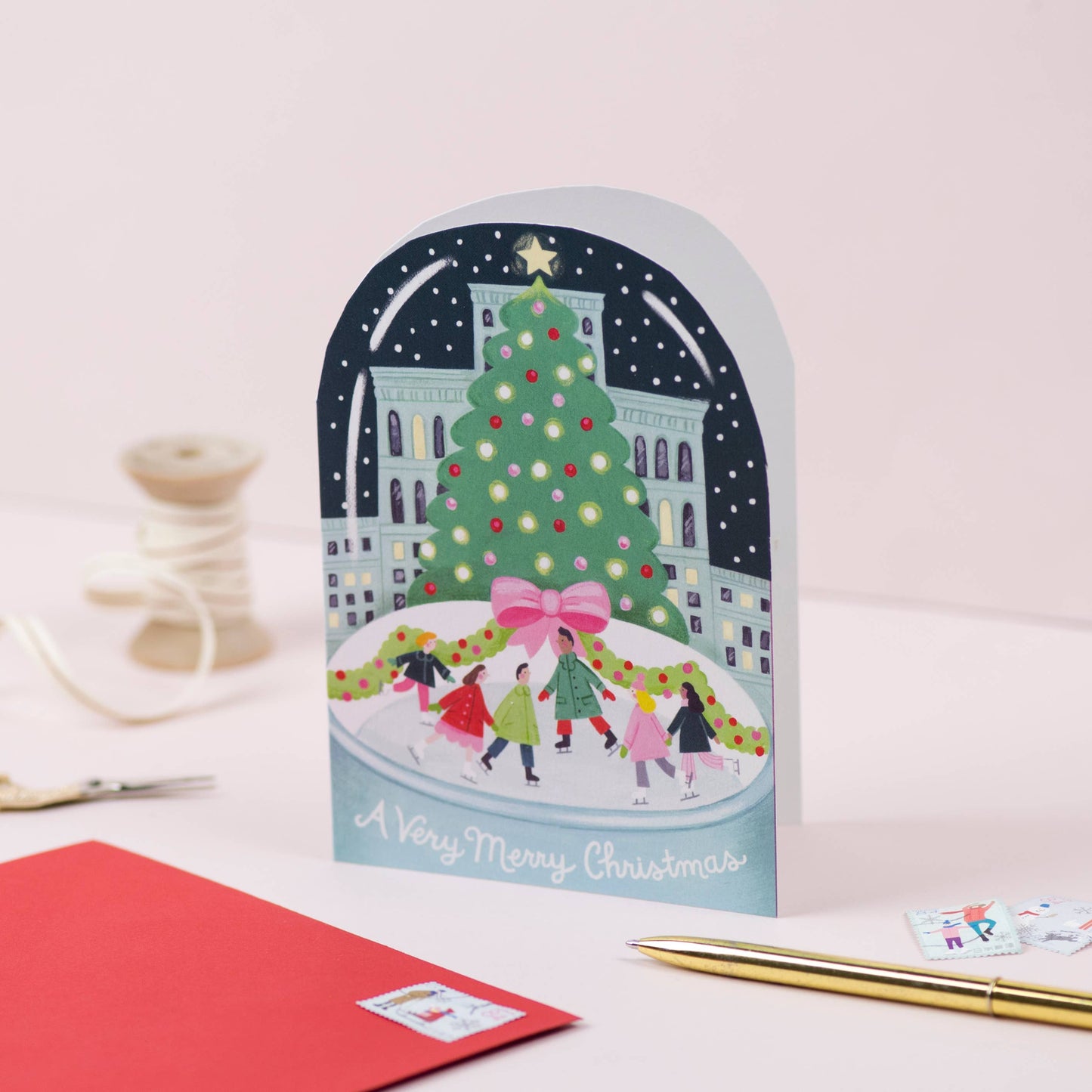 Christmas Card. Snow Globe illustration with a Christmas Tree and skaters.  Text reads A very Merry Christmas.