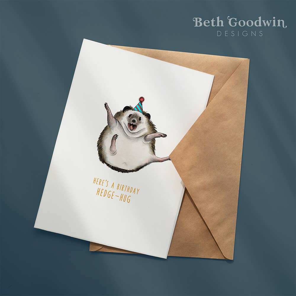 Greeting card with a hedgehog illustration and envelope on a dark blue background, featuring 'Beth Goodwin Designs'.