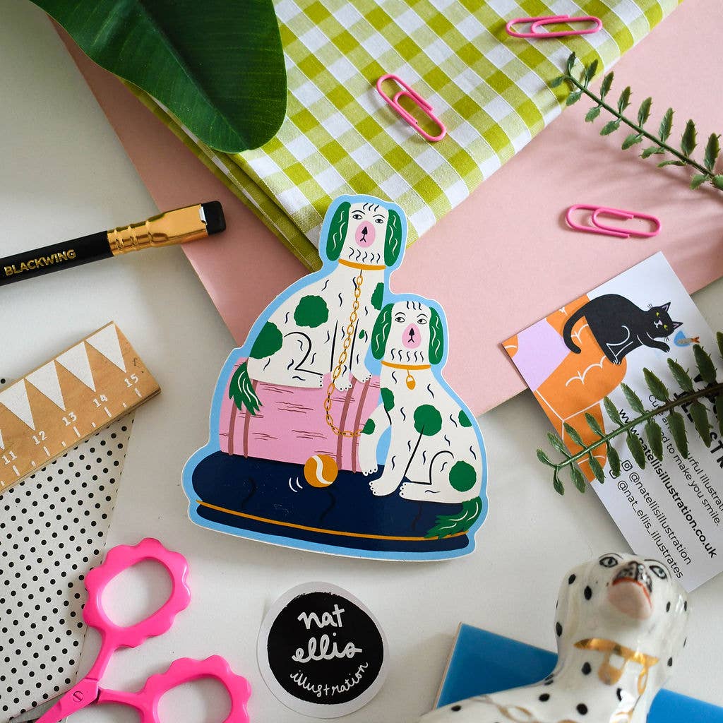 Sticker of a dog and person sitting together on a checkered tablecloth with stationery items around.