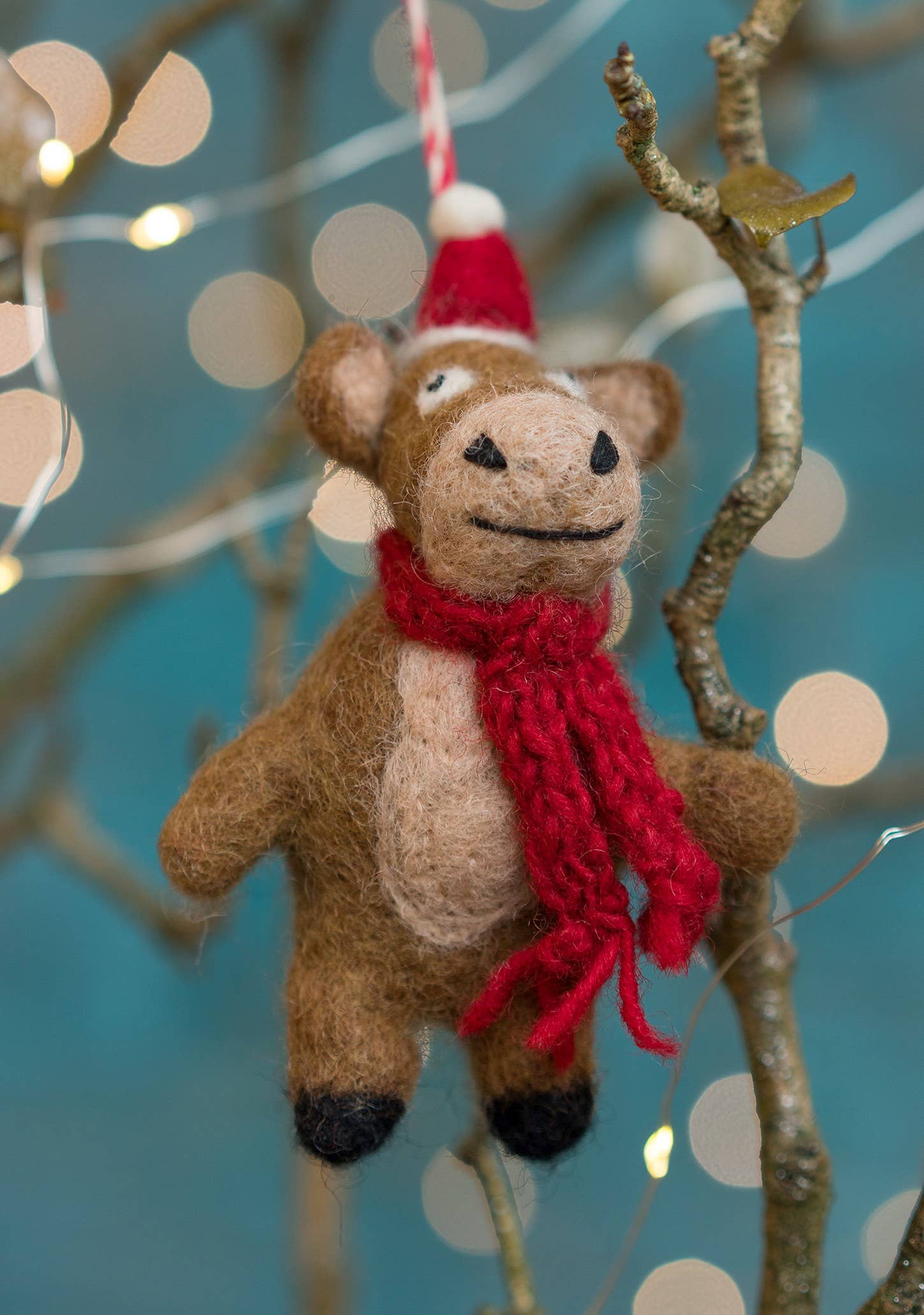 Felt hanging cow with hat and scarf.