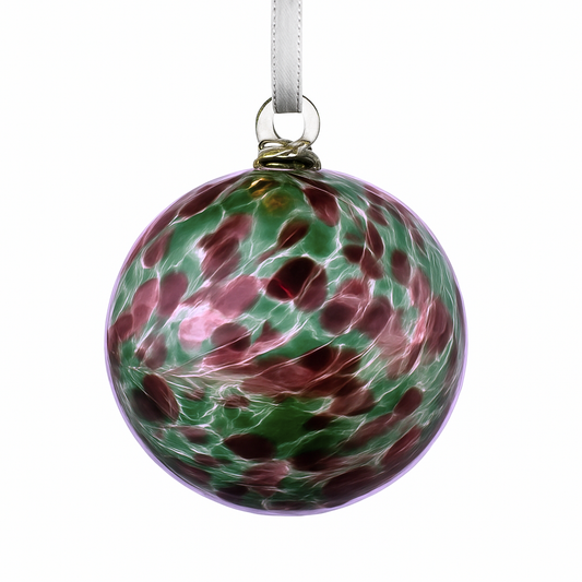 Bauble with ribbon hanging against a white background.