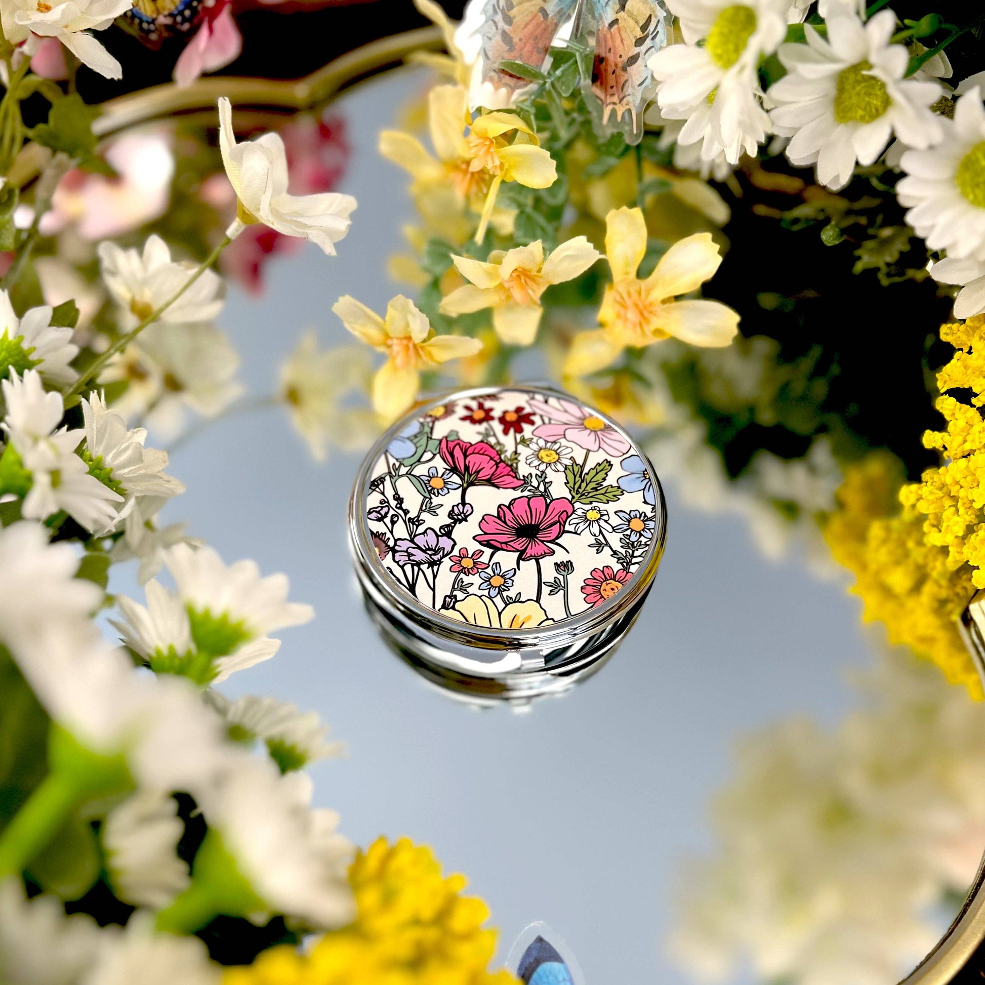 Small mirror compact with pretty floral design.