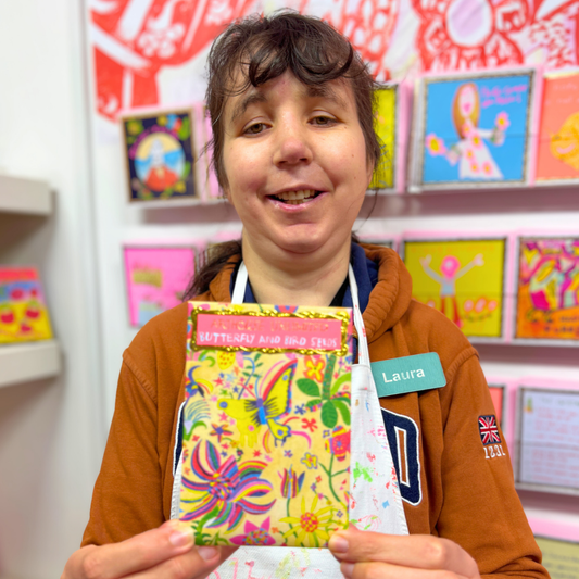 Person holding a colorful card in a store setting with shelves in the background