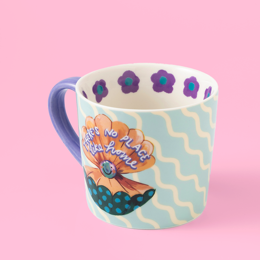Colorful mug with floral design and text on a pink background