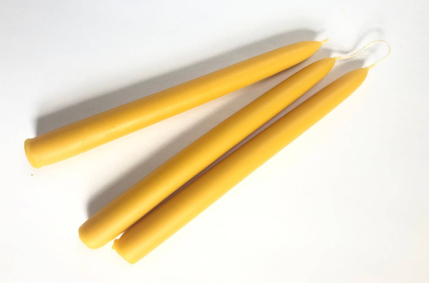 Three yellow candles on a white background