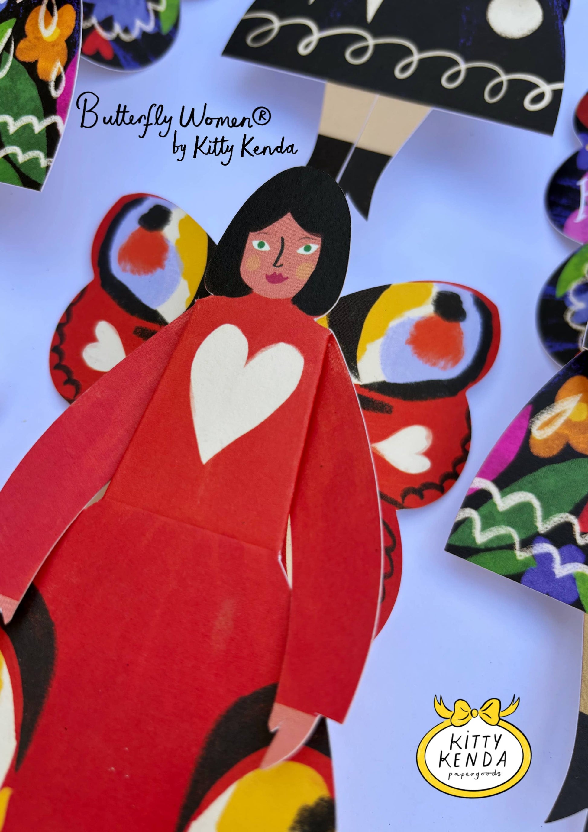 Butterfly-themed paper doll with a red dress and heart design, featuring Kitty Kenda's branding.