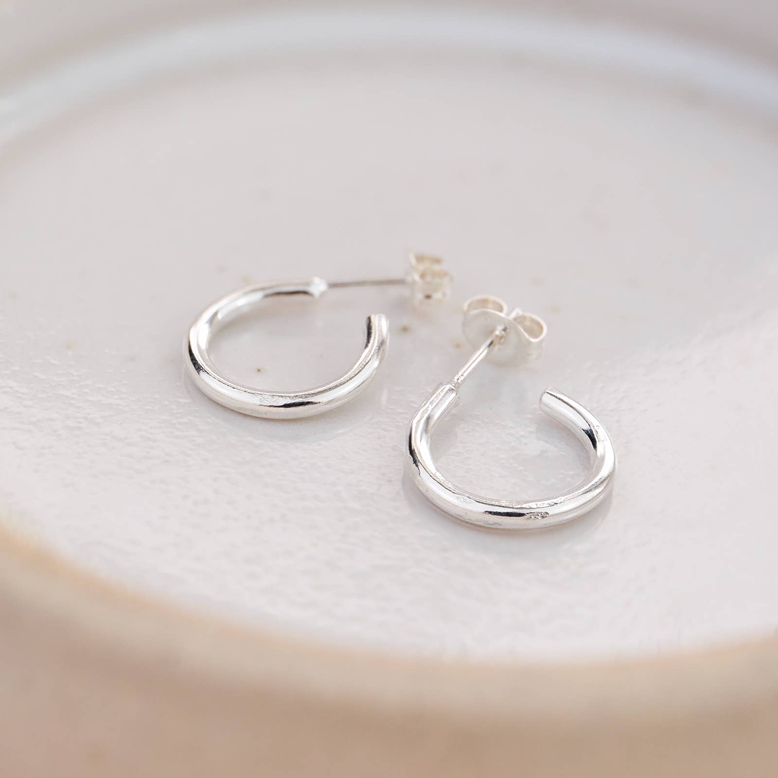 Silver hoop earrings on a light background