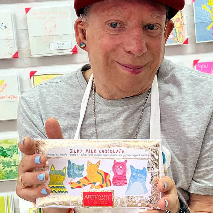 Person holding a box of Arthois Silky Milk Chocolate with colorful packaging