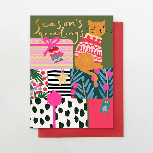 Colorful holiday card with a cat in a sweater and gift patterns on a white background