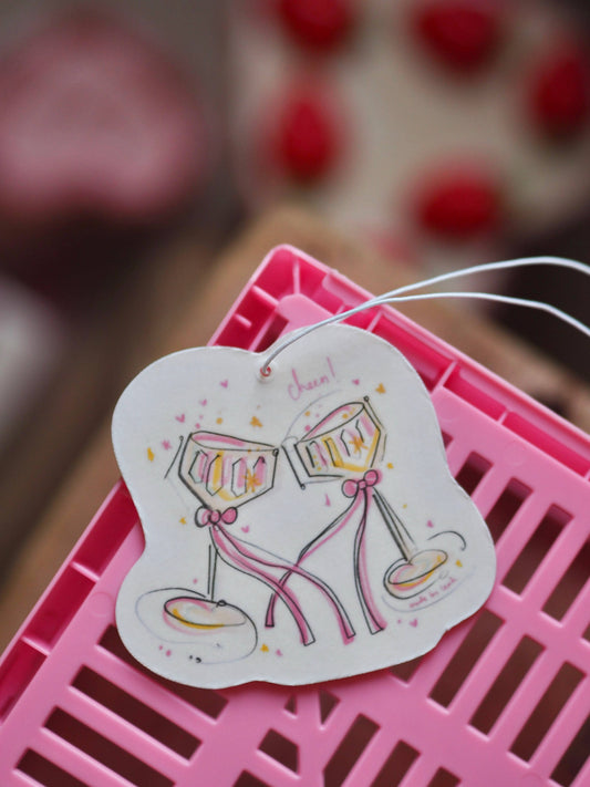 Decorative card with champagne glasses on a pink surface