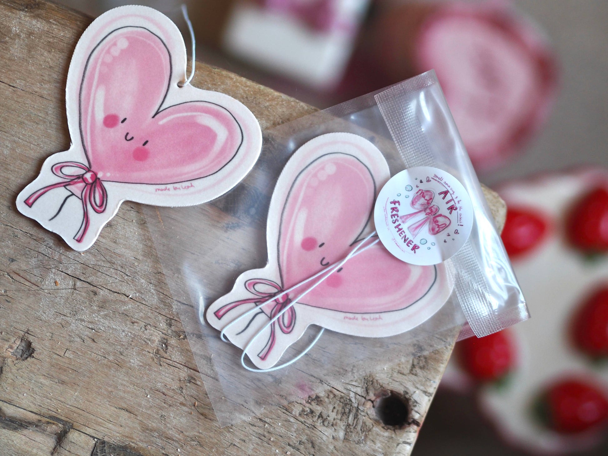 Heart-shaped pink stickers with a bow design on a wooden surface.