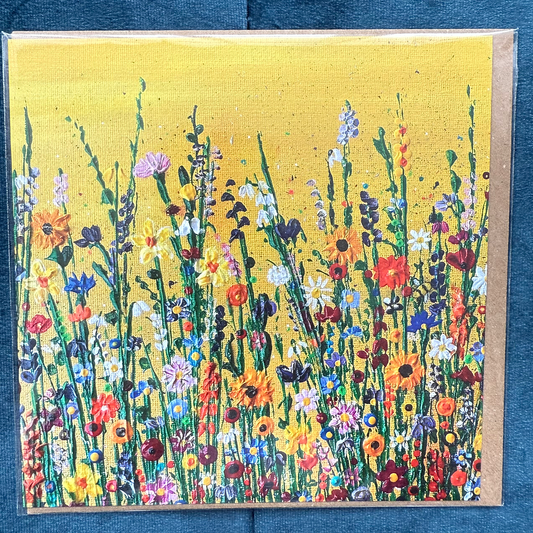 A square card depicting vibrant hand-painted wildflowers under a golden yellow sky.