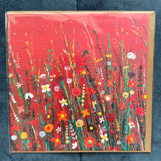 A square card featuring a vibrant red background with colourful painted flowers.