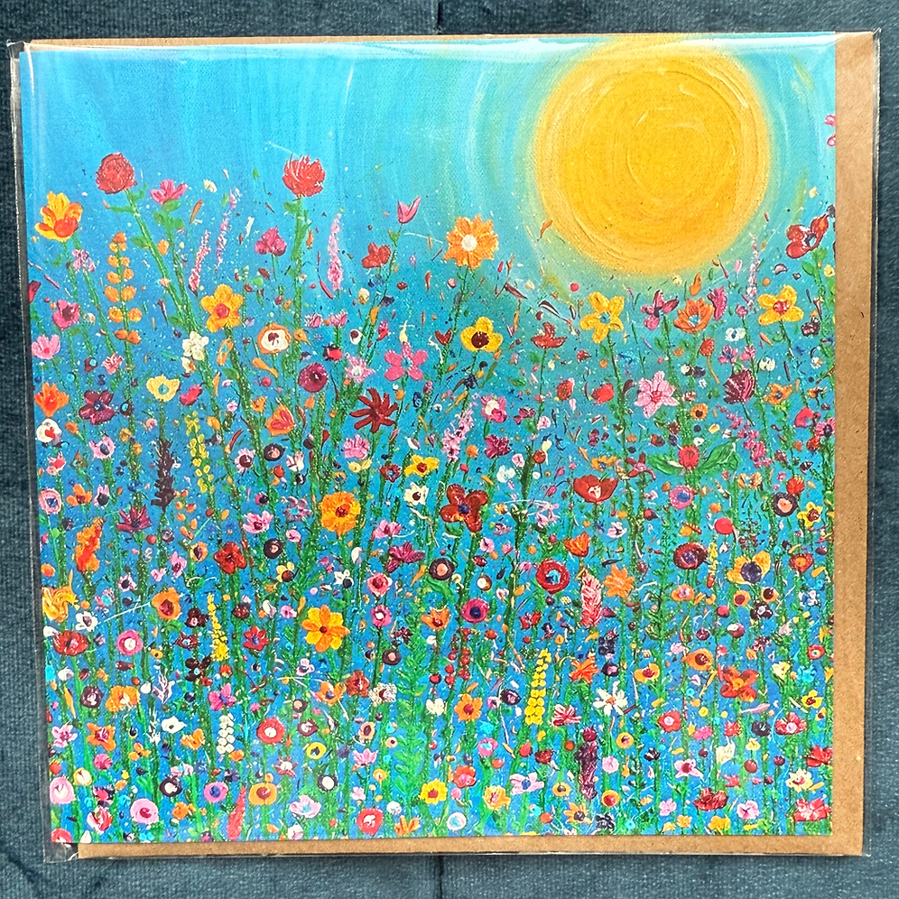 A bright and colourful square card of vibrant wildflowers against a blue background, with the sun in the sky.