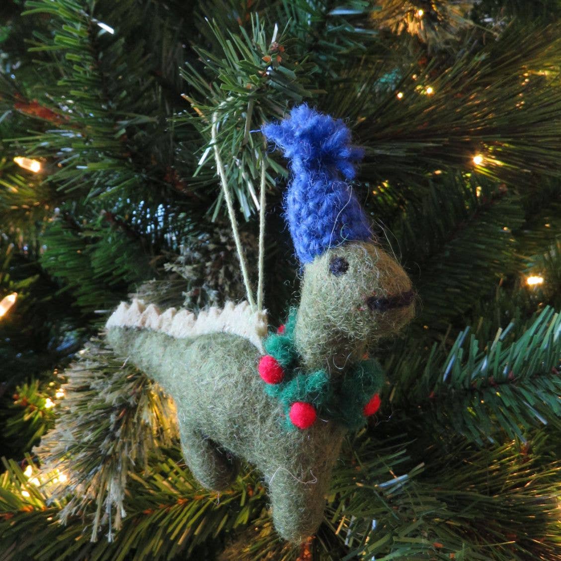 Handmade Christmas ornament of a reindeer with a blue hat on a decorated tree.