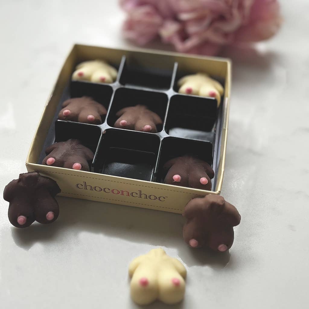 Chocolate candies shaped like animal butts in a box with 'choconchoc' branding, surrounded by pink flowers on a light background.