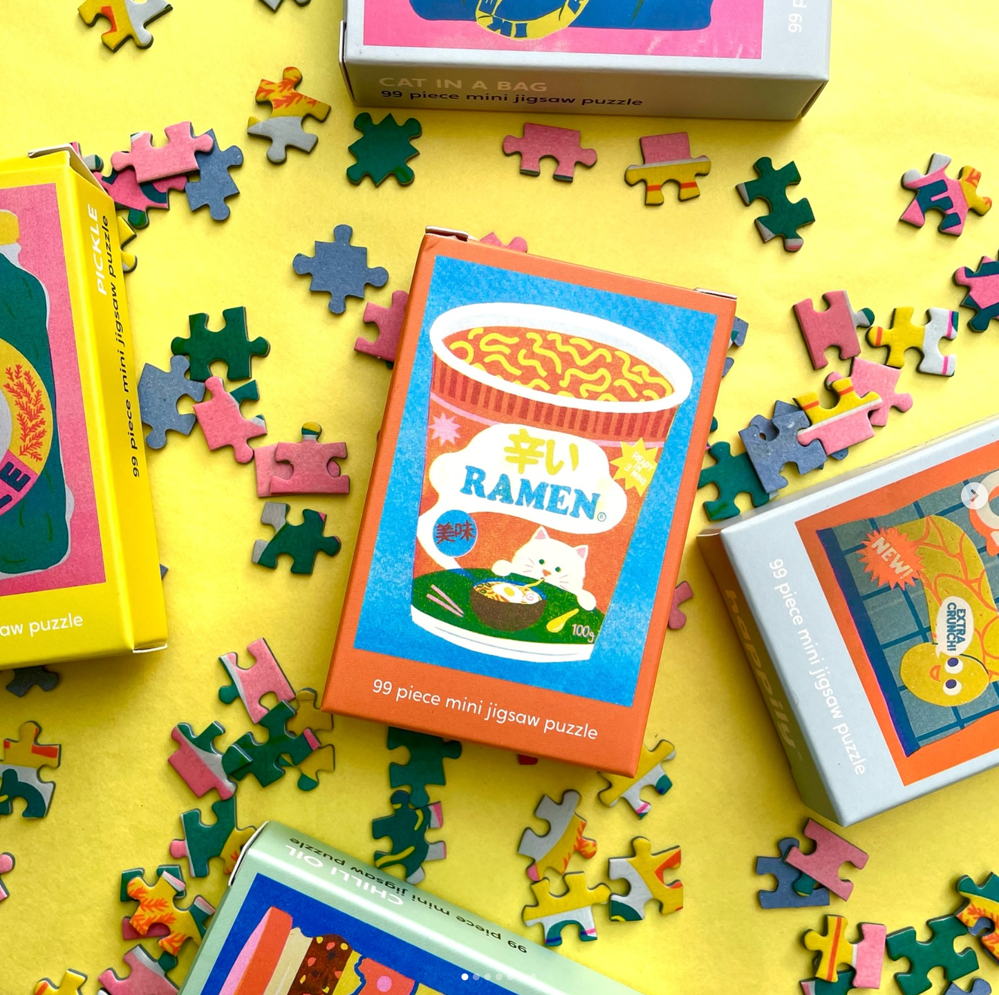 Colorful mini jigsaw puzzles with 'Ramen' theme on a yellow background