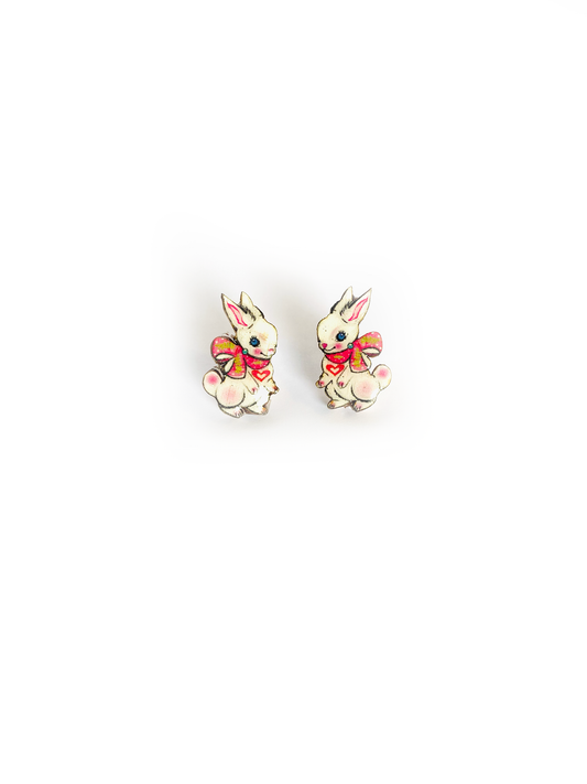 Little white bunnies with ribbon studs, made from wood and resin.