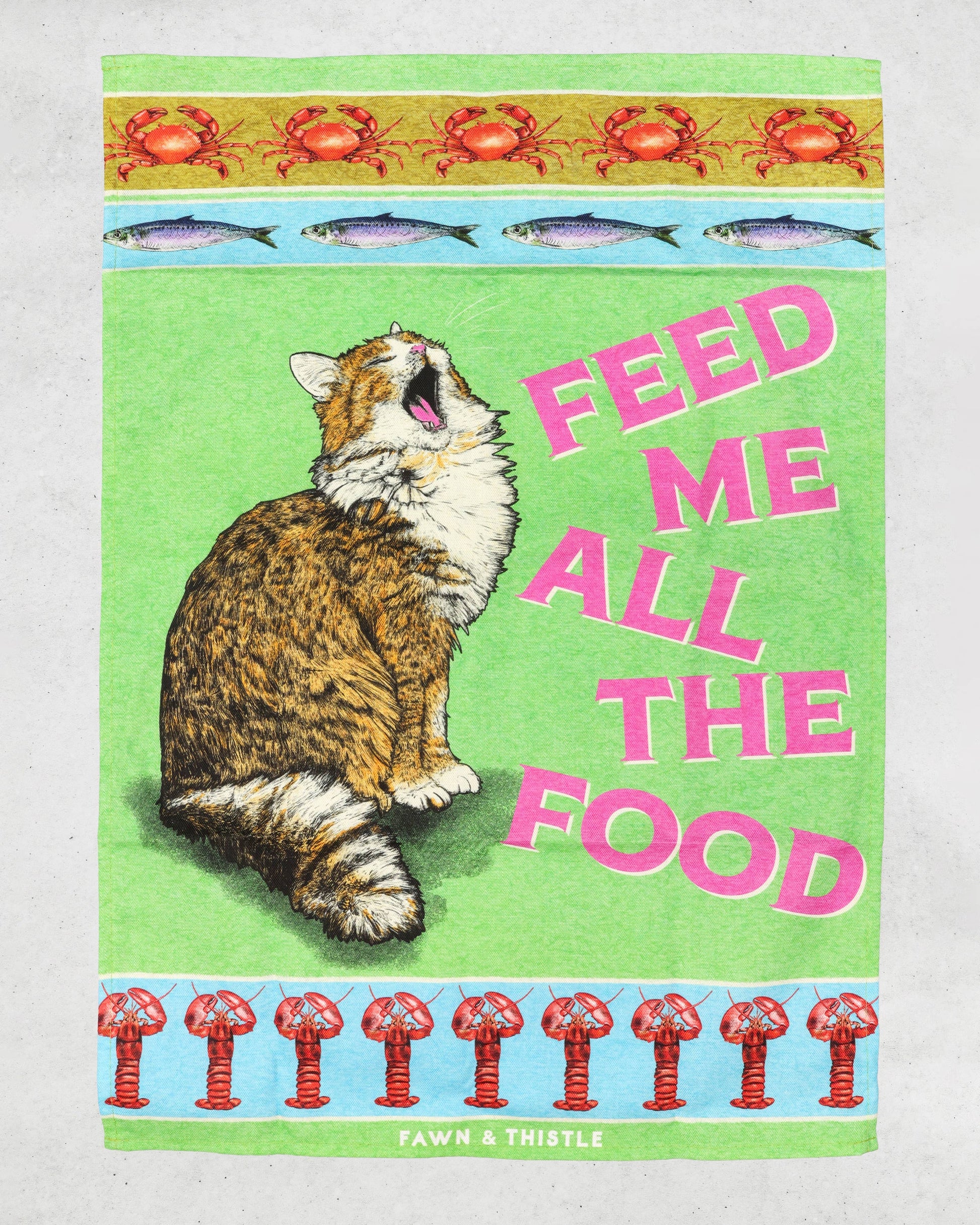 Tea towel with a cat illustration and text 'Feed Me All The Food' on a green background.