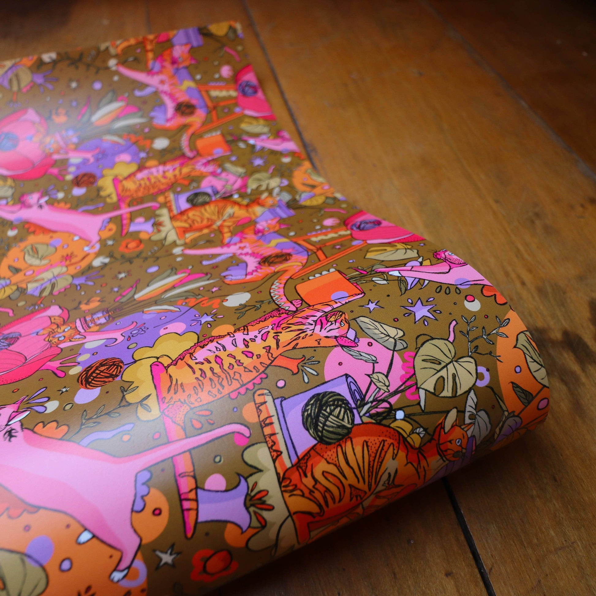 Bright gift wrap featuring cats, plants, feathers and plants.