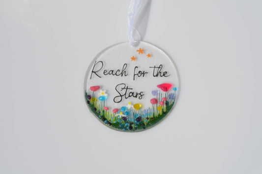 Decorative hanging disc with floral design and 'Reach for the Stars' text on a white background