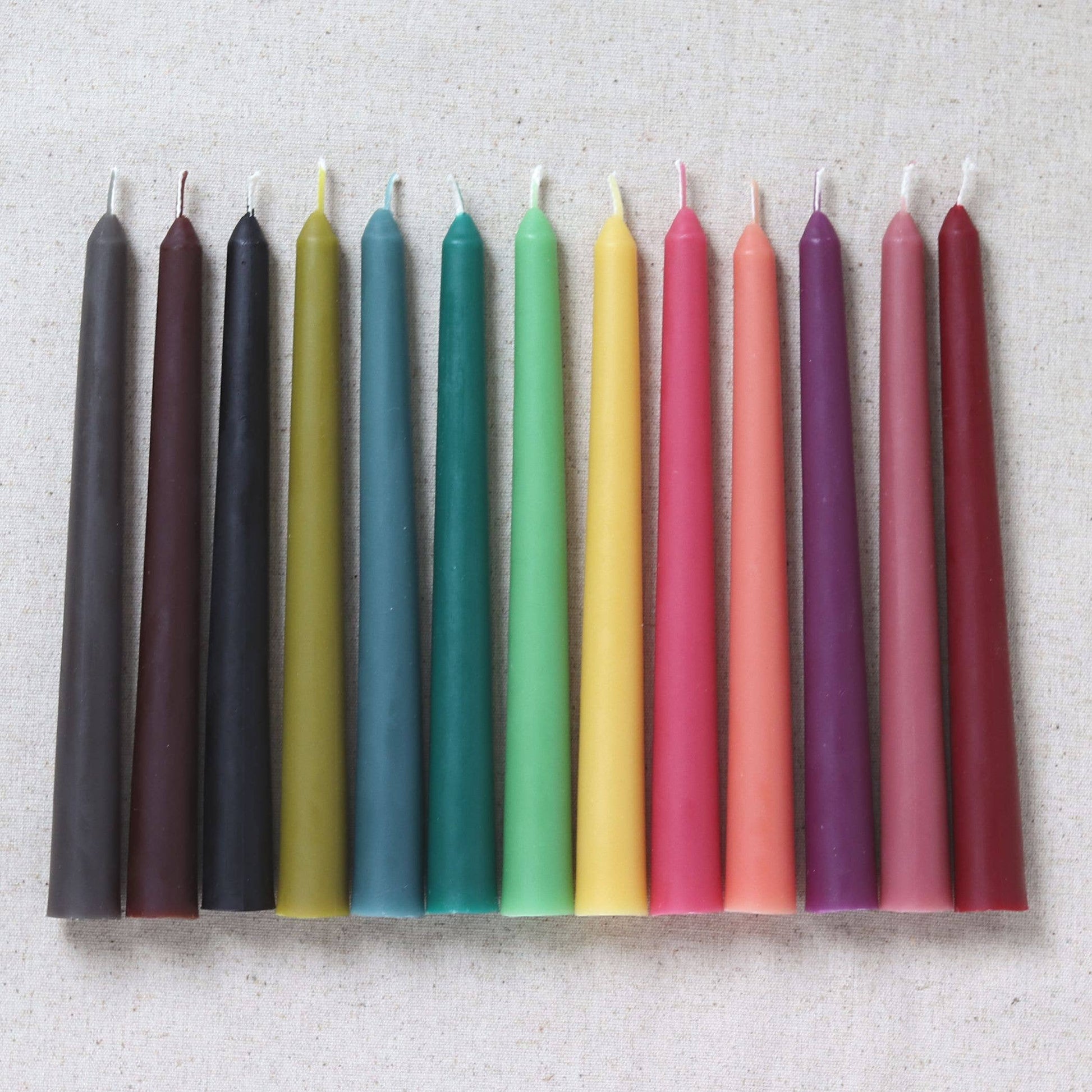 Row of colorful candles on a textured surface