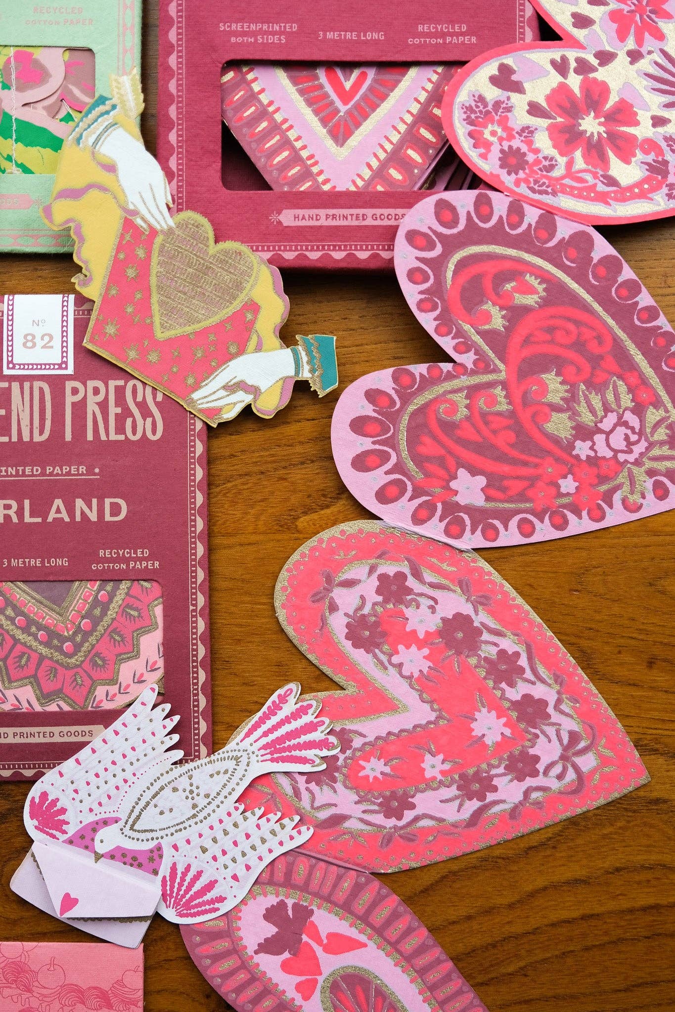 Heart-shaped cards with floral designs on a wooden surface, featuring 'End Press' branding.