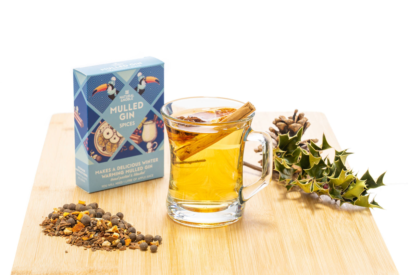 Mulled gin with a box of mulled gin mix on a wooden surface.