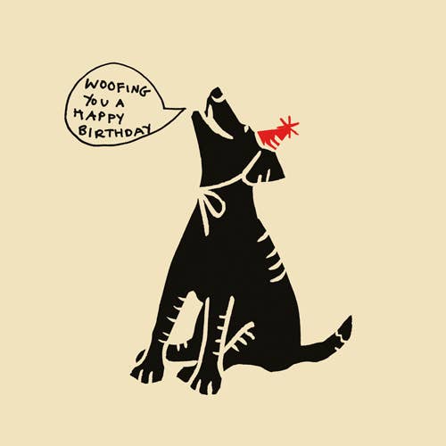 black dog in red party hat on a cream background with speech bubble saying woofing you a happy birthday.