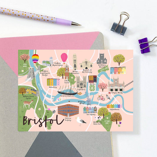 Colorful map of Bristol on a pink card with stationery items on a white background