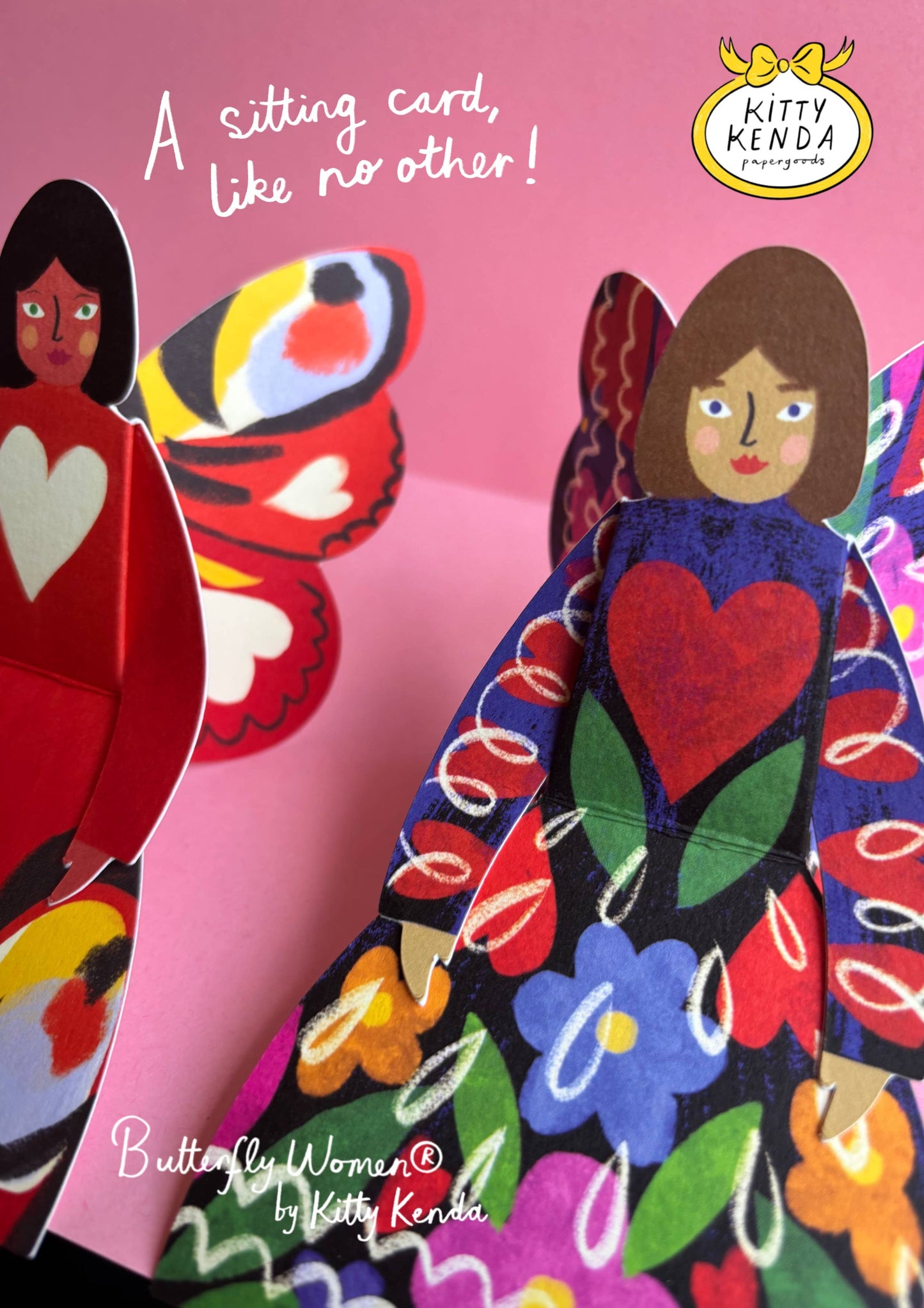 Colorful paper dolls with a butterfly and text on a pink background, featuring the Kitty Kenda brand.