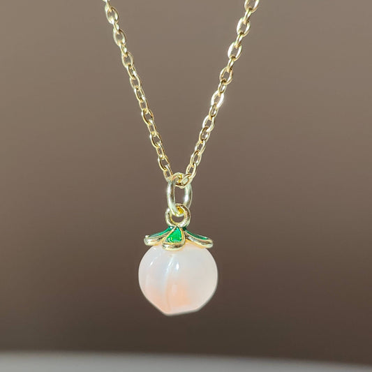 a natural yuan yan stone on a gold plate chain.