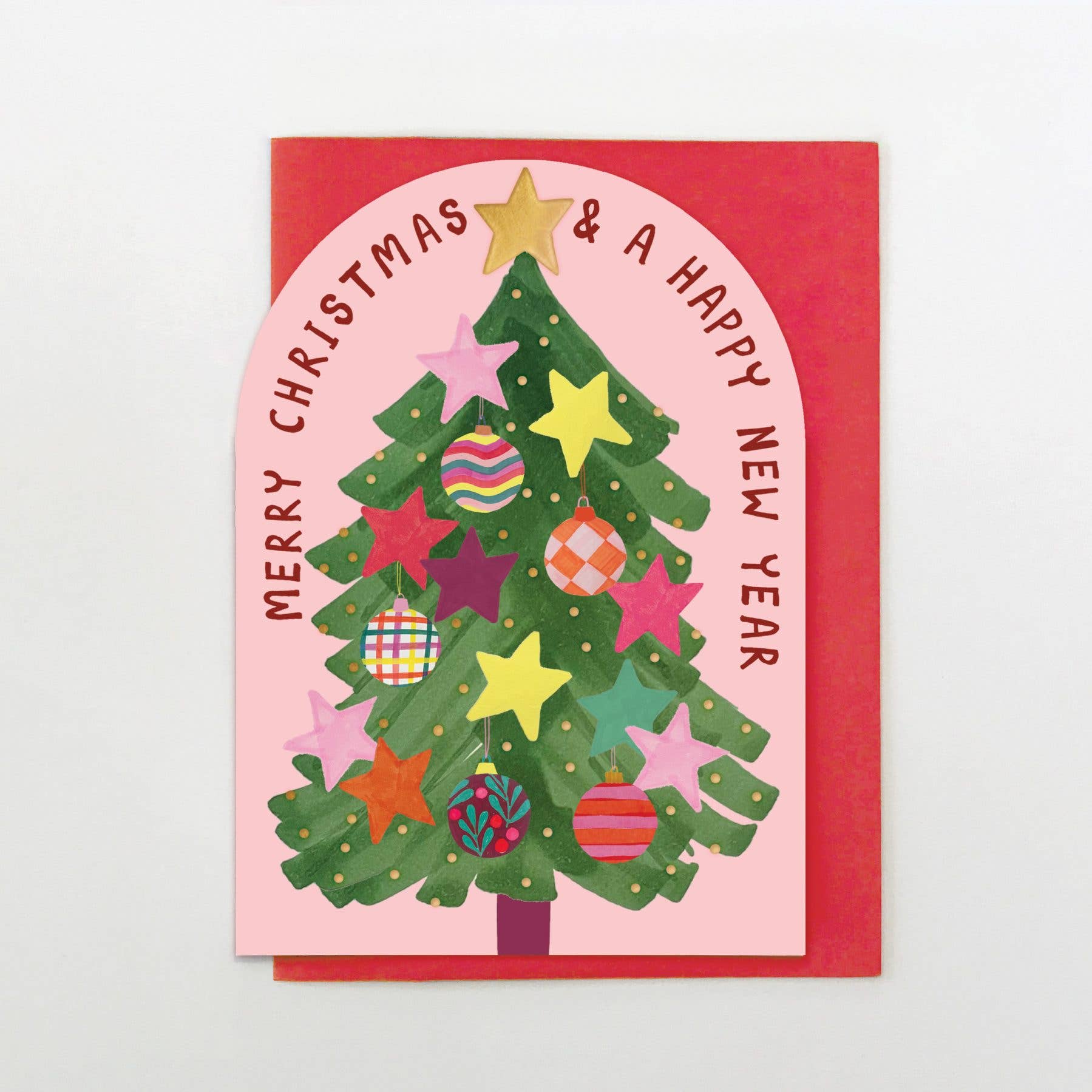 Christmas card with a decorated tree and colorful ornaments on a pink background