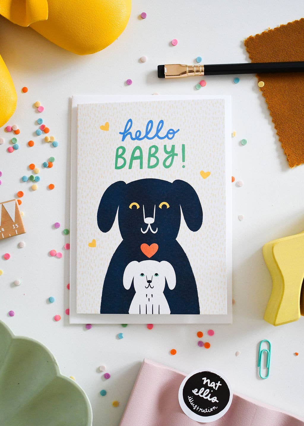 Greeting card with a dog illustration and 'hello BABY!' text on a colorful background.